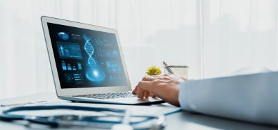 Doctor studying genetic disease in DNA research with laptop, analyzing genetic data