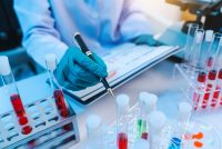 Scientists in lab coat working with test tubes