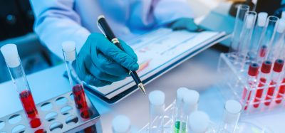 Scientists in lab coat working with test tubes